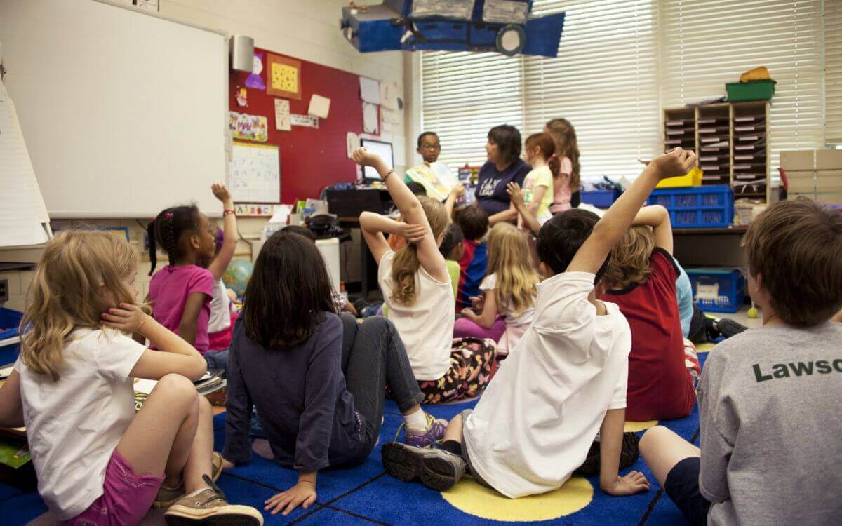 Students siting on a floor in a classroom