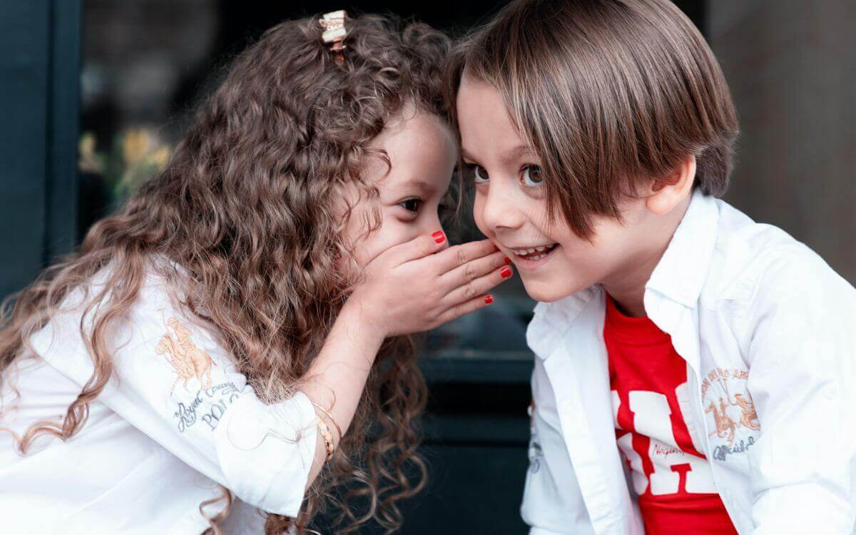 Two girls whispering and smiling