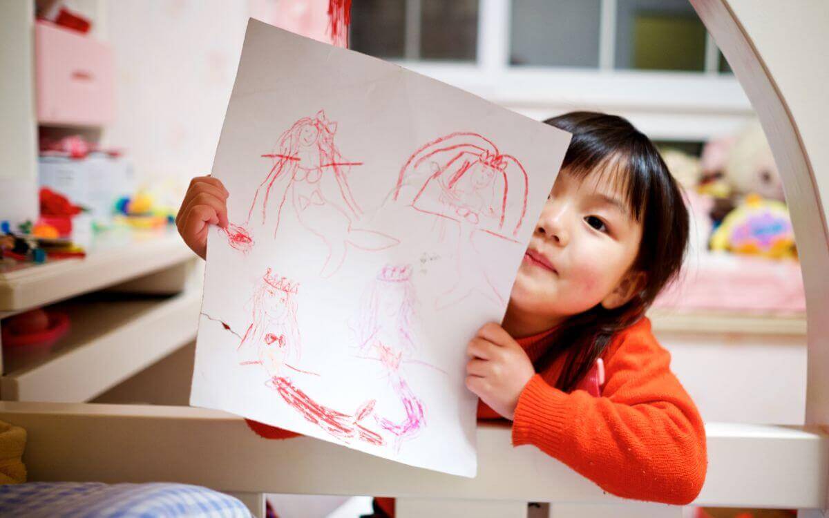 A little girl showing her drawing